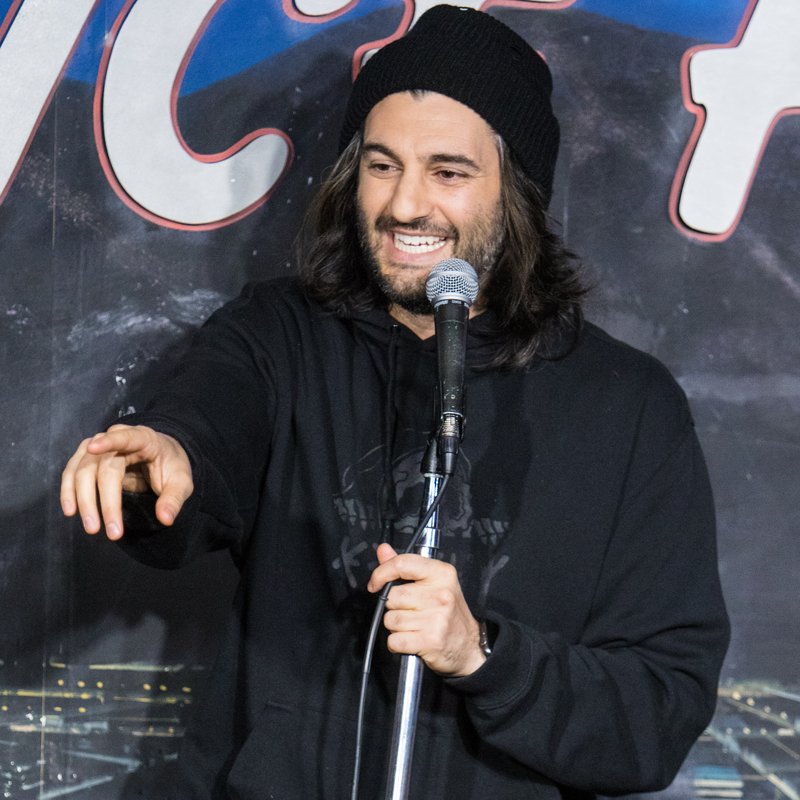Amir K on stage at a Cool Beans Comedy show.