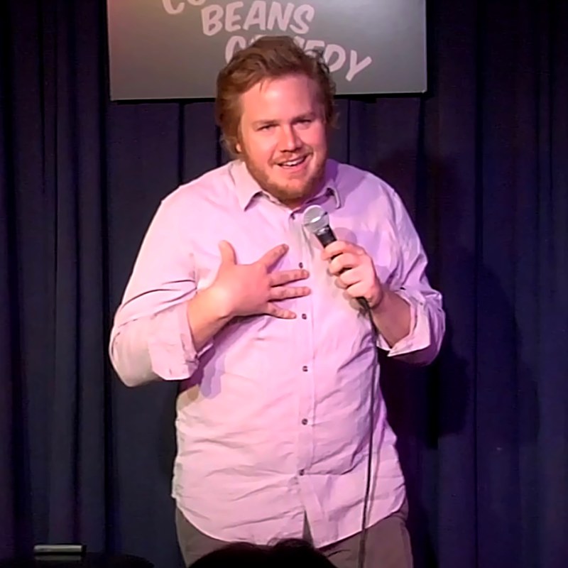Josh McDermitt on stage at a Cool Beans Comedy show.